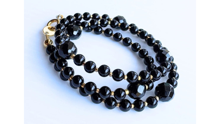 丸玉とカットオニキスを組み合わせた黒のネックレス。ゴールドのパーツがポイントになった上品なデザイン。