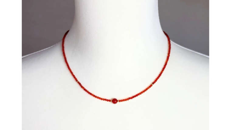 シンプルな一粒赤めのうを中央に配したネックレスの着用イメージ。やわらかい赤色が首元を上品に彩るデザイン。