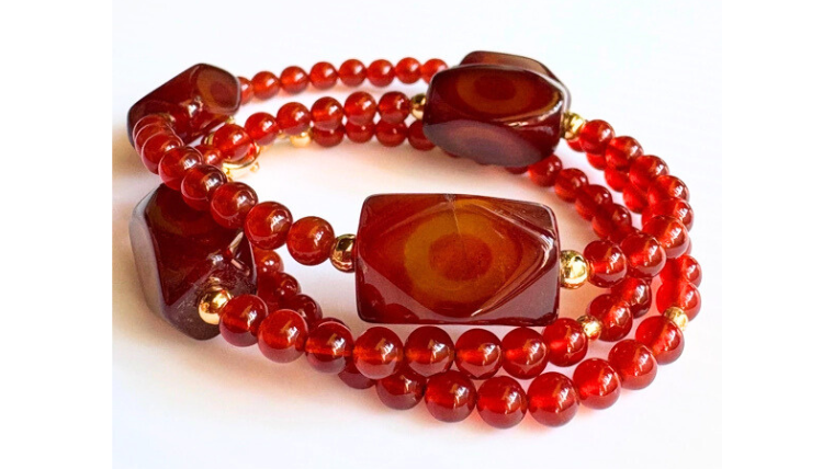 縞模様の入った赤めのうビーズを贅沢に使ったネックレスの全体画像。深い赤とゴールドパーツが上品に映えるデザイン。