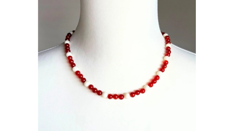 赤めのうと本白珊瑚を使用したネックレスをトルソーに着用した画像。赤と白のバランスが上品で、首元を華やかに見せる天然石アクセサリー。