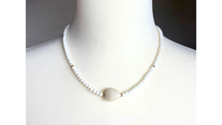 ホワイトオニキスのネックレスをトルソーに着用した写真。派手すぎず上品で50代女性に似合う落ち着いた印象