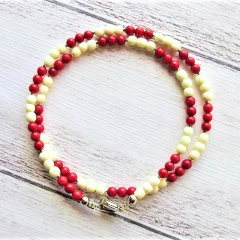 Red coral and white shell beads alternating necklace, flat lay