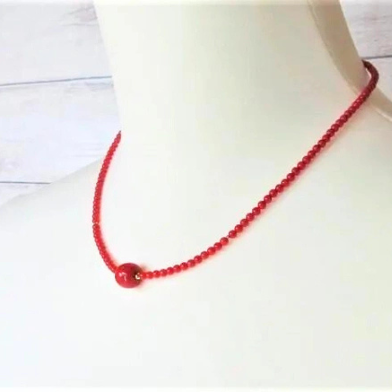 Blood red coral necklace with apple-shaped center bead on mannequin